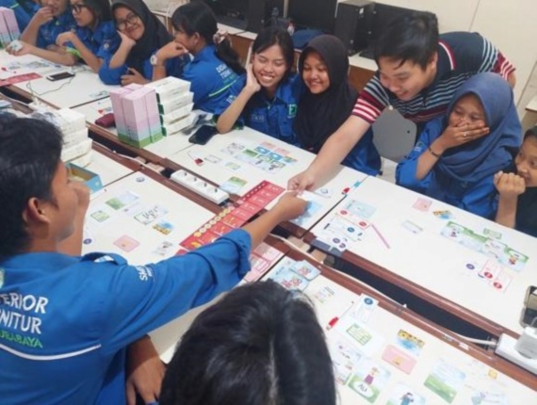 Mahasiswa ITS anggota tim KKN Abmas ketika memeragakan bermain Tata Harta bersama para siswa SMKN 12 Surabaya. Foto Humas ITS